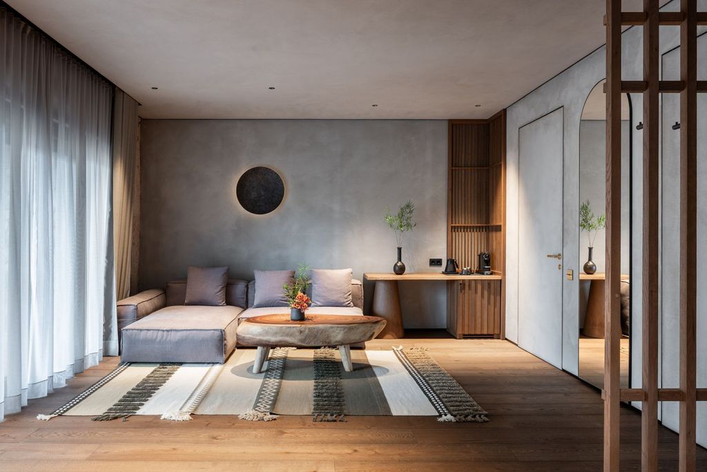 Private Lakefront Suite terrace with relaxing sofa, wooden decor, and calming lakeside scenery.