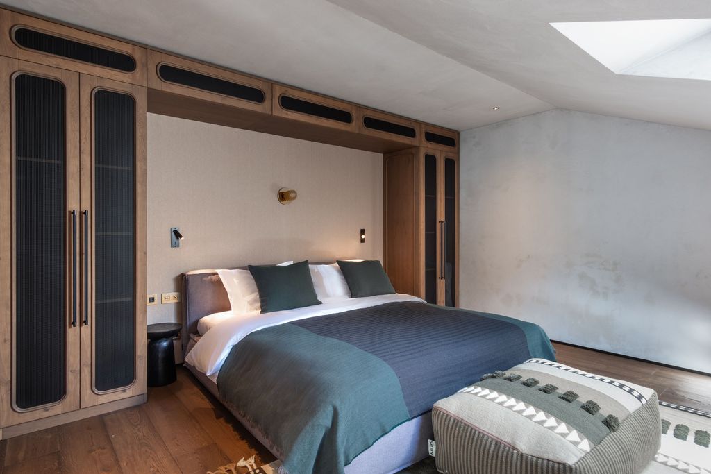 Loft suite with king-size bed, cozy lounge, and warm natural wood interior accents.